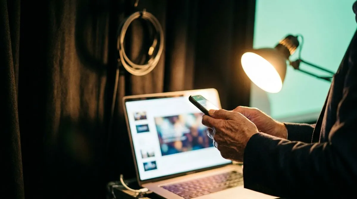 Presenter testing a phone clicker against a laptop running slides backstage